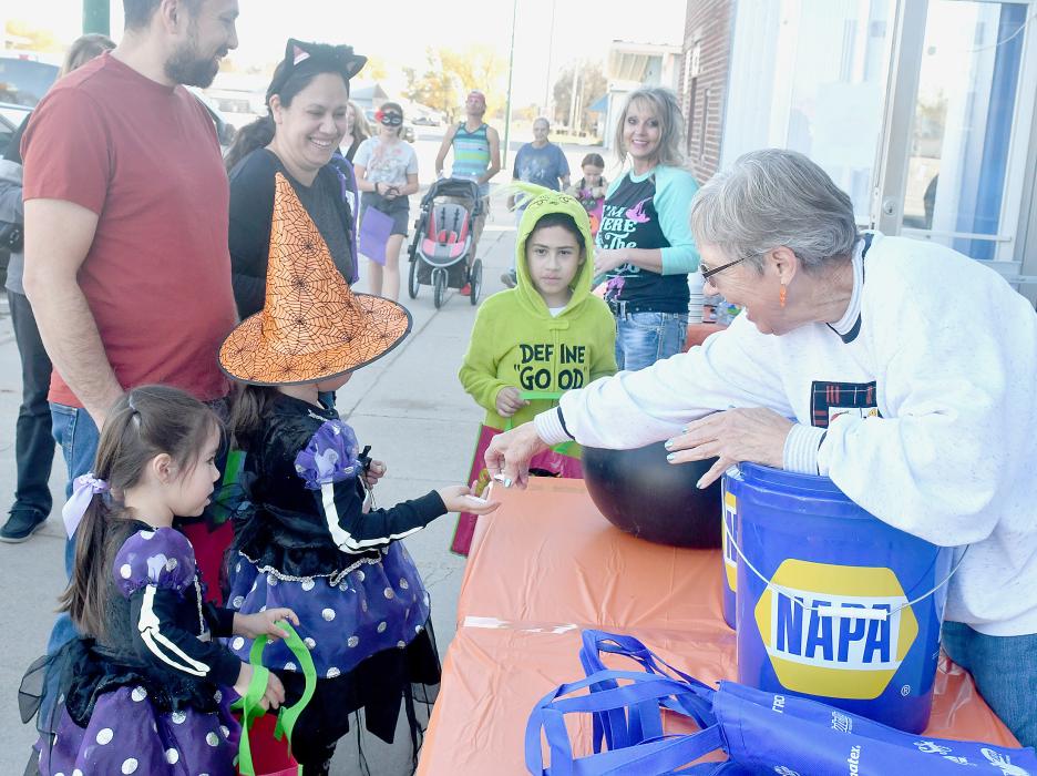 (Left and Right) Tables of goodies were set up on Main Street in front of businesses with a wide variety of items to choose from including candy, Hot Wheel Cars, pencils, Koolaide Pouches, toys, hot chocolate, Trick or Treat bags and several other items.