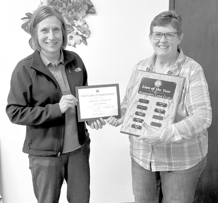 Geraldine Erickson presents Connie Lentz with a certificate and her name was placed on the Lion of the Year plaque.