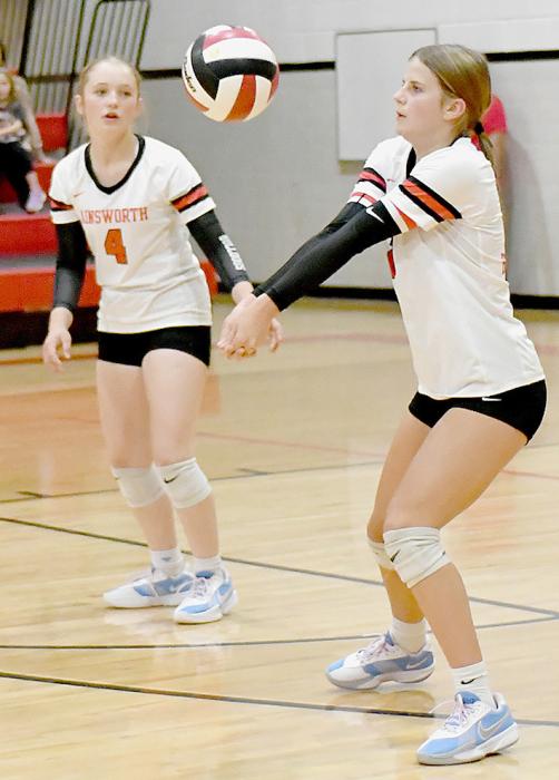 Jaylee Good bumps the ball for her teammates to send over the net during their match up against the North Central Knights. Ready to assist is teammate Kensey Walz.