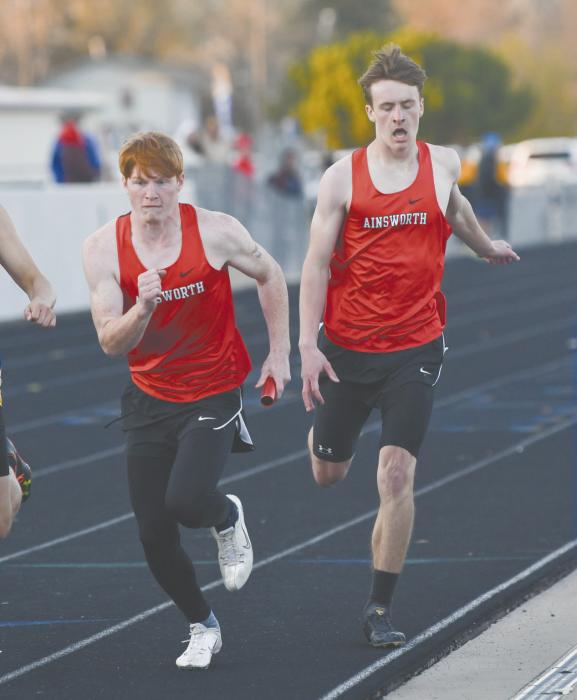 Senior Sam Titus receives the baton from sophomore Graham Duester during the 4x400 meter relay. The team of Duester, Titus, Chris Fernandez, and Jacob Ortner placed seventh at the invite, running a 3:47.28.