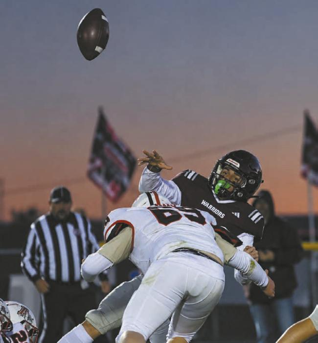 John Lewis (69) hits the Warrior's quarterback during the game on Friday.