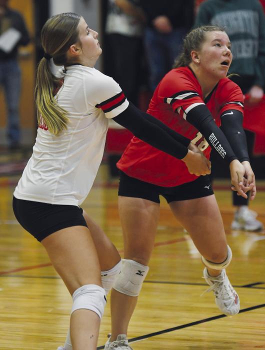 Junior Jaylee Good (left) and sophomore Lily Beel (right) both dig at a ball hit over the net by a Mustang.