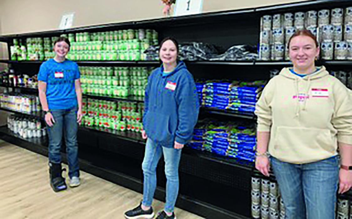 Payton Moody, Jaden Lee, and Bristol Goodwin stock food at the Center for People in Lincoln.