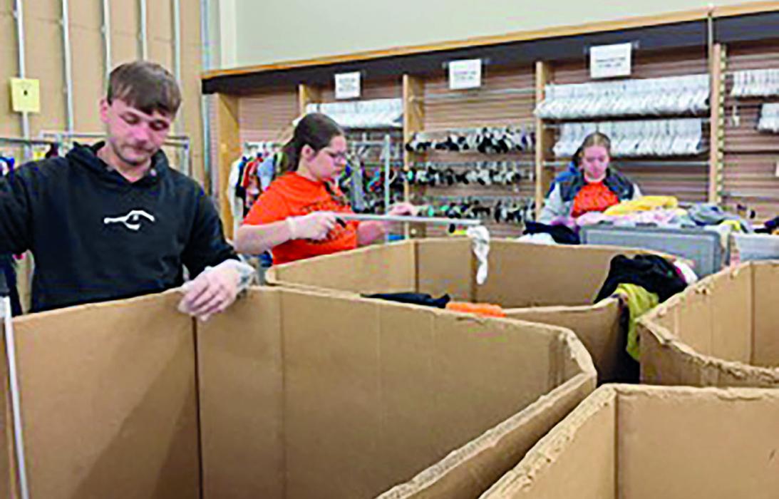 Owen Blumenstock, Hannah Beel, and Bristol Goodwin sort through clothing items at The People’s City Mission.