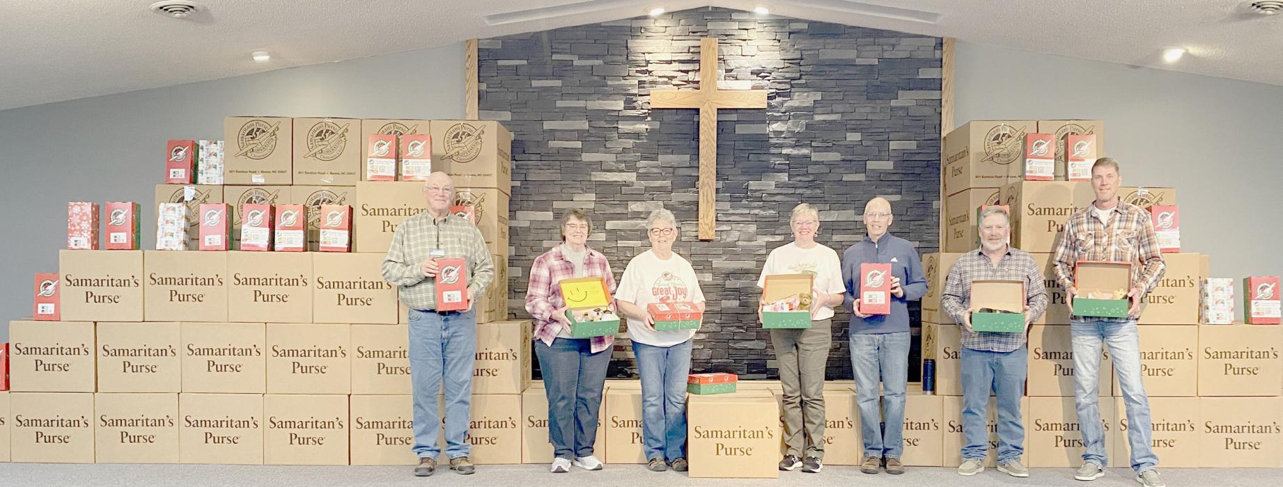 Some of the members of the Ainsworth Free Mission Team and Shoebox Committee (left to right) Duane Saner, Sheila Peterson, Konny Saner, Clisty Taylor, Mike Schrad, Russ Wentworth, and Brad Arens, stand among the 1,321 shoeboxes to be loaded into the trailer to be hauled off to the Operation Christmas Child distribution center in Denver to be flown to their destinations.