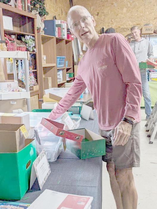 Mike Schrad and Brad Arens fill the boxes with the various items that have been donated for the Christmas boxes.