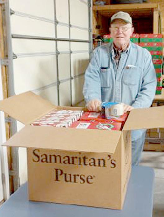 Duane Saner fills this big box with 15 shoeboxes filled with a variety of donated items.