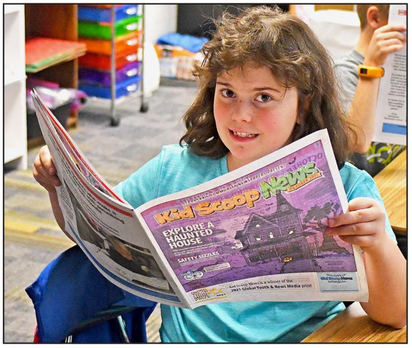 Third grader Raynee Thiede enjoys browsing her copy of the October 2021 issue of Kid Scoop News.