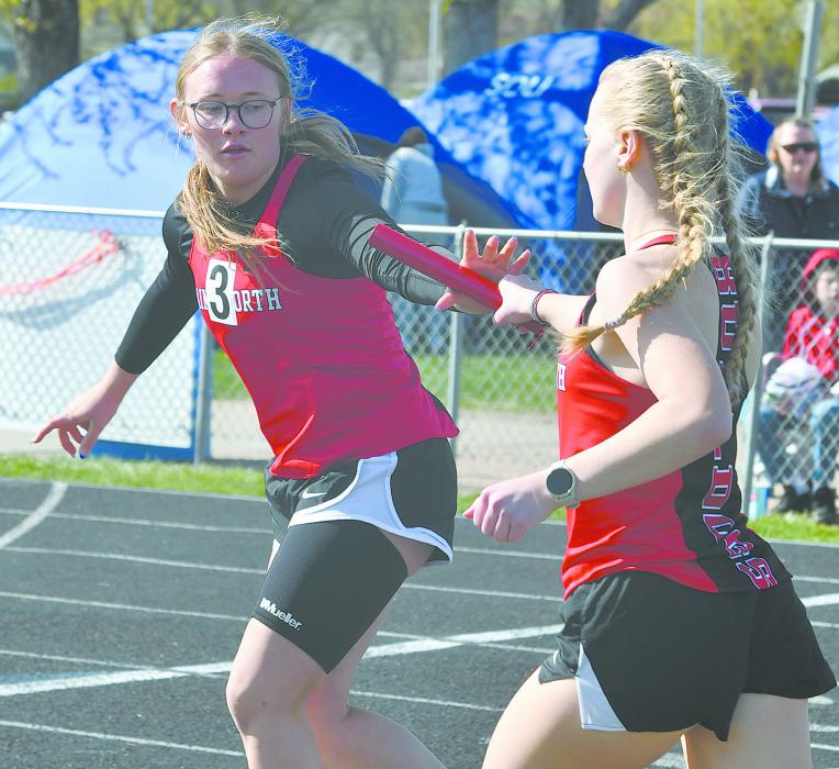 Gracyn Painter (left) and Kiley Orton (right) make a handoff during the 4x400 meter relay last season.