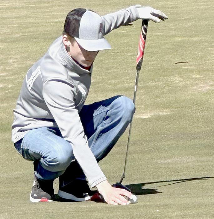 Jhett Hollenbeck lines up a putt during the Ainsworth Triangular. Hollenbeck placed fourth with a score of 46.