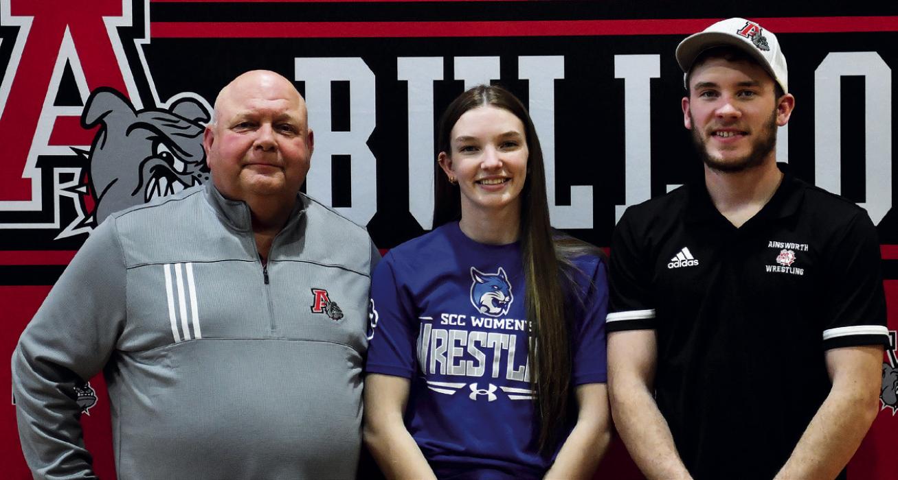 Pictured with Jolyn are her high school girls wrestling coaches, Todd Pollock and Oren Pozehl.