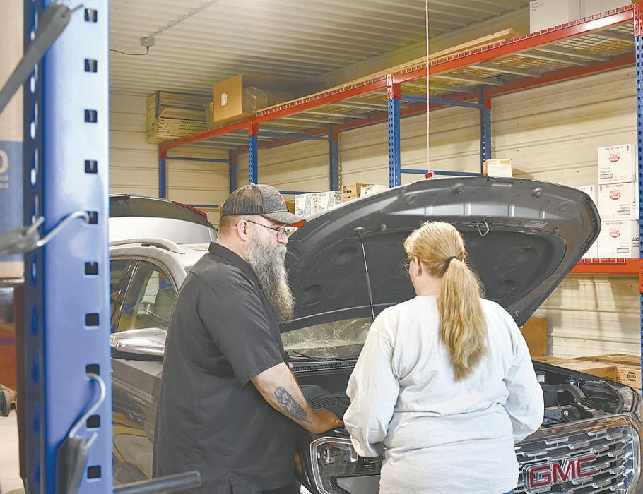 Ryan Cleal gives one attendee a tour under the hood of a GMC SUV.