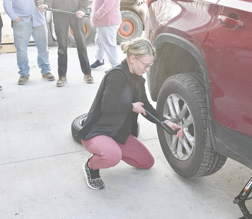 Macey VonHeeder tightens lugnuts as she puts a tire back on a vehicle. Tony Buckles took advantage of the nice spring weather and allowed multiple women to test their skills with tires.