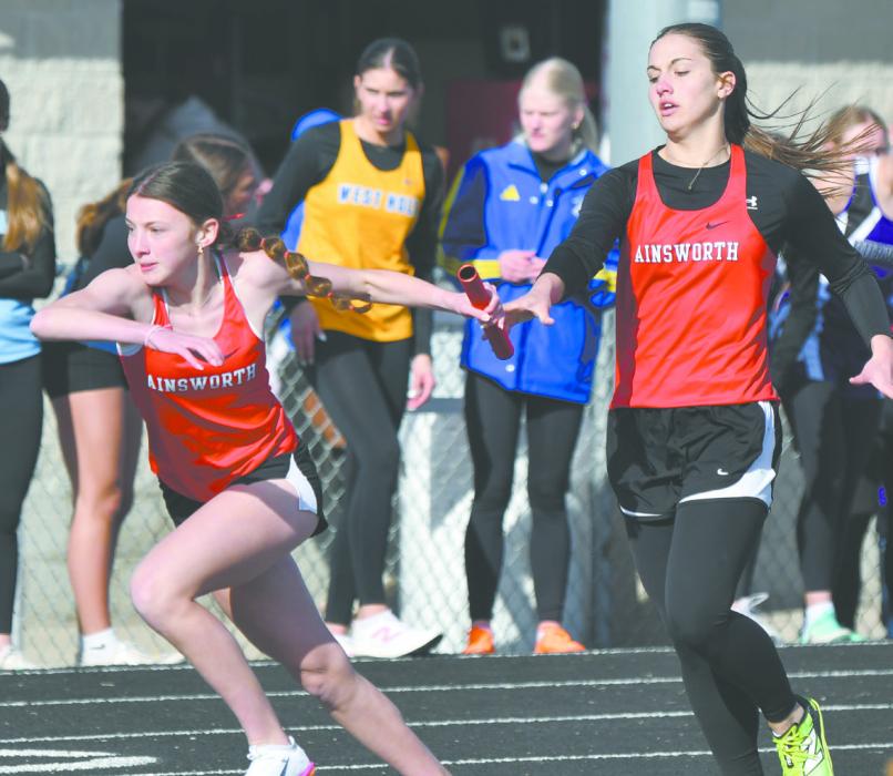 Willa Flynn (right) hands the baton off to Reagan Moody during the 4x400 meter relay. The relay team placed third.