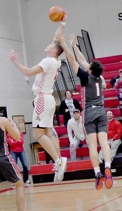 Carter Nelson goes high to pull in a rebound against Valentine.