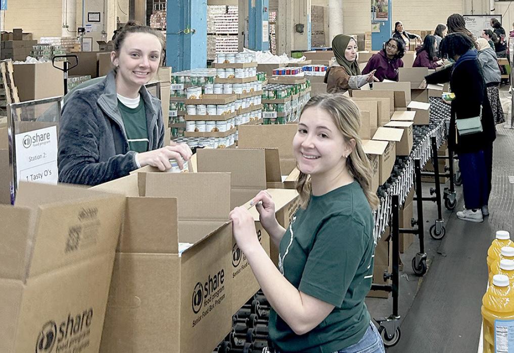 Cameryn Goochey (left) is pictured working with Libby Willkom (right). The pair were on an Elks National Foundation Service Trip and worked on an assembly line at Share Food Program. They helped pack 400 boxes of food for senior citizens experiencing poverty/ food insecurity in the Greater Philadelphia Region.
